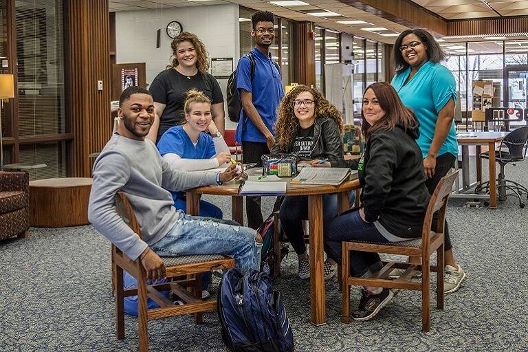 Large group of student around table in library