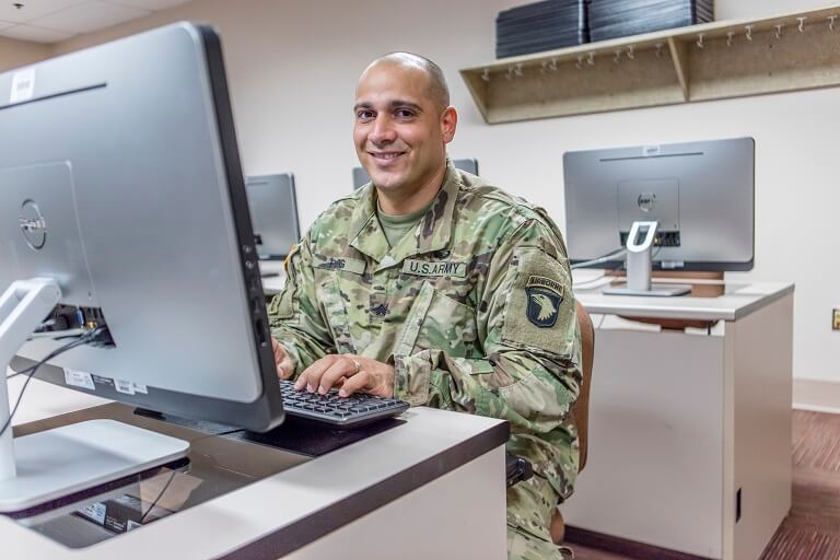 Man in military uniform smiling at camera