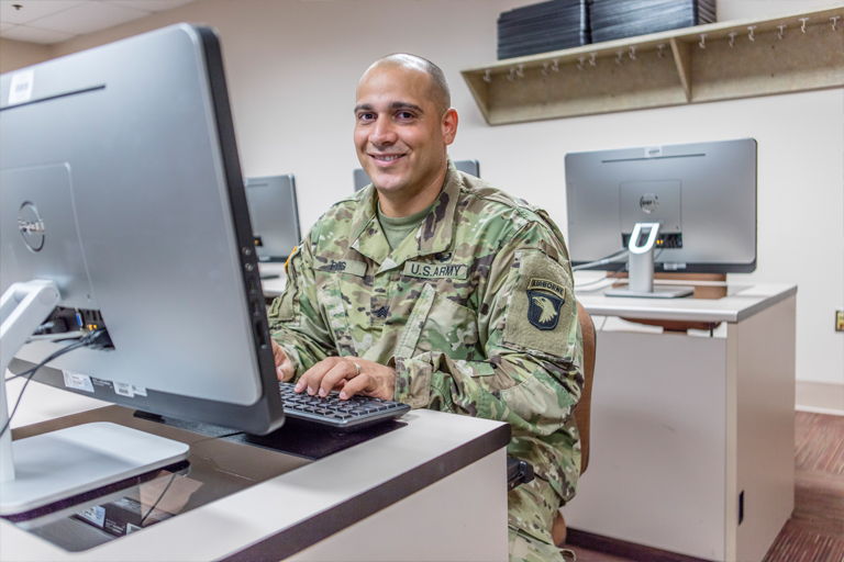 Male student soldier at computer