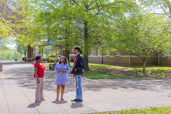 2 students standing outside with an admissions councelor