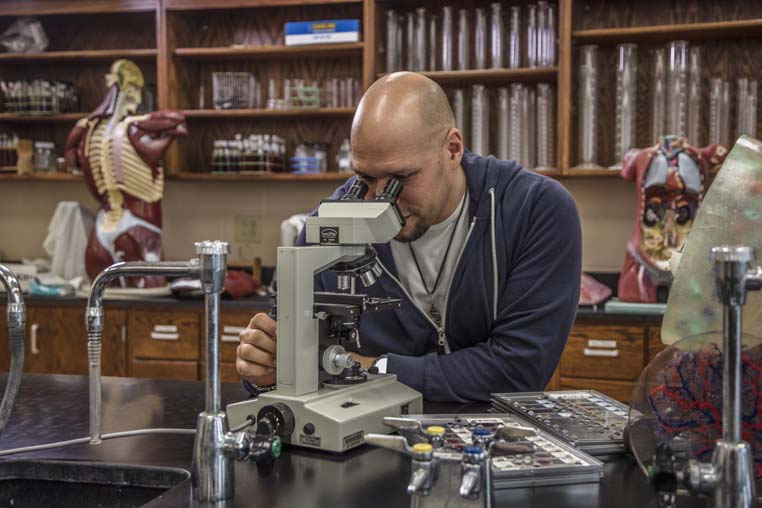 Student looking in microscope.