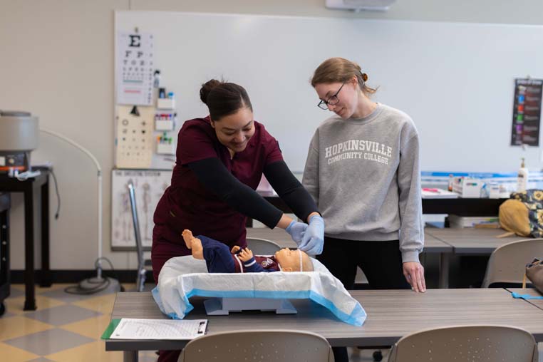 Students weighing an infant. 