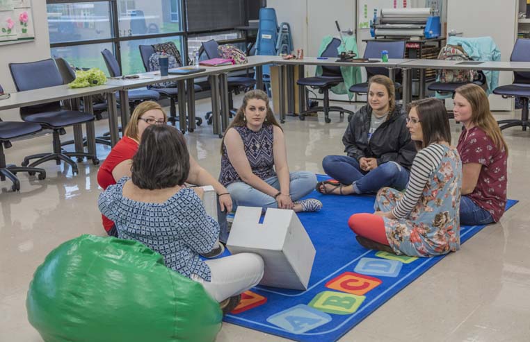 Group of adults sitting in the floor. 