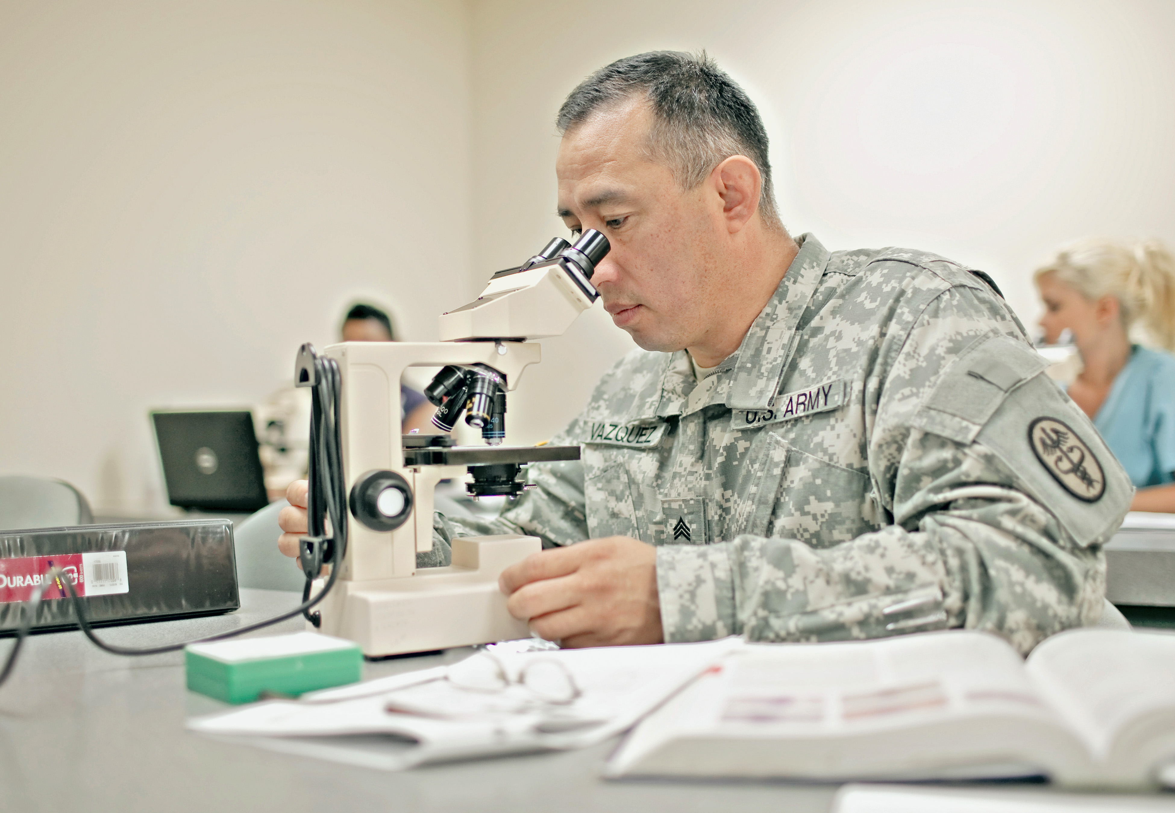 Soldier looking through a microscope.
