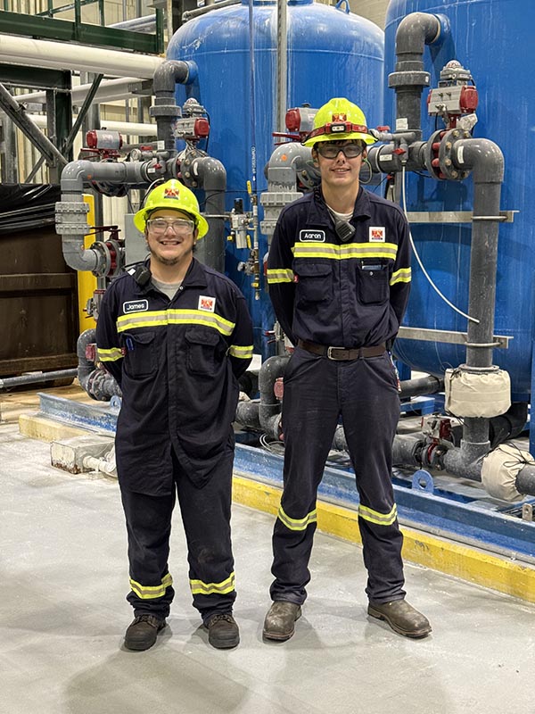 Two students at an industrial partner's facility